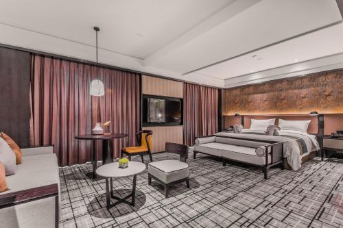 a hotel room with a bed and a couch at Qingdao Treasure Hotel in Qingdao