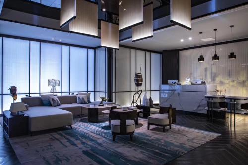 Qingdao Treasure Hotel في تشينغداو: غرفة معيشة مع أريكة وطاولة