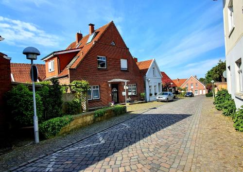 a cobblestone street next to a brick house at Ferienwohnungen Bentheimer Altstadt in Bad Bentheim