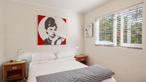 ein Schlafzimmer mit einem Bett und einem Bild eines Mannes in der Unterkunft Tongariro Adventures in Kuratau