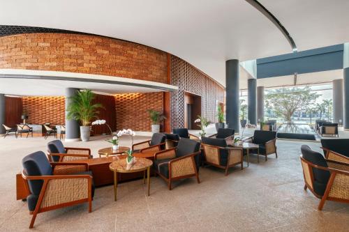 a lobby with chairs and tables and a brick wall at Awei Metta (Yangon) in Yangon