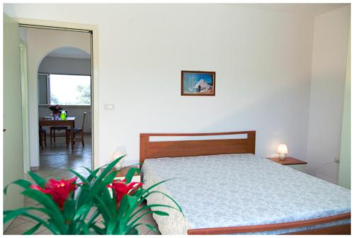 a bedroom with a bed and a dining room with a table at Appartamenti Corciulo in Salve