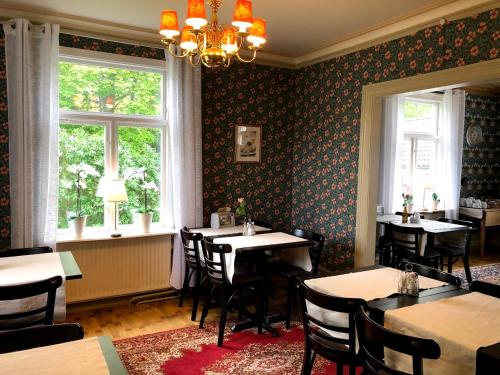 a dining room with tables and chairs and windows at Villa Frideborg in Henån