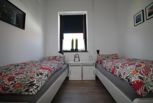 a bedroom with two beds and a window at Ferienwohnung 14.sechs - Jahrhundertwende trifft Moderne in Oberhausen
