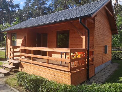 a log cabin with a porch and a pitched roof at MARWIKOWE Domki Wypoczynkowe in Sieraków
