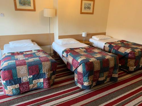 A bed or beds in a room at Strathpeffer Hotel 