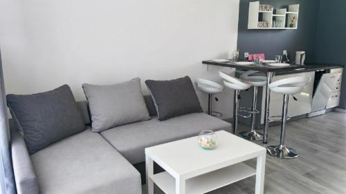 salon z kanapą i stołem w obiekcie Over Lake-domki,apartamenty w mieście Mielno