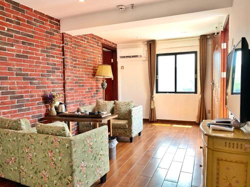 a living room with two chairs and a brick wall at Mumian inn in Chaozhou
