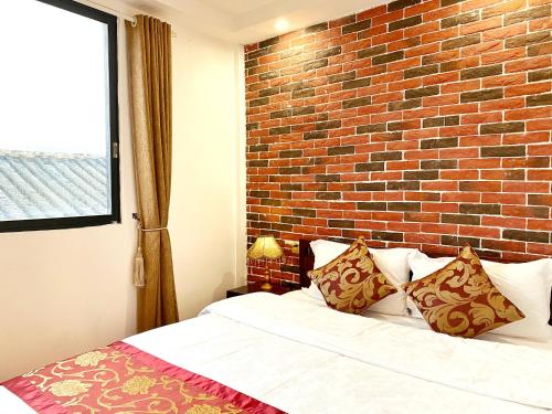 a bedroom with a brick wall and a bed at Mumian inn in Chaozhou