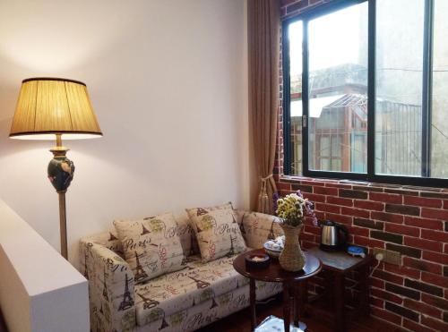 a living room with a couch and a brick wall at Mumian inn in Chaozhou
