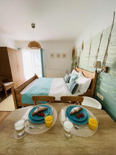 a bedroom with a bed and a table with plates of food at Barackvirág Apartmanház in Tihany
