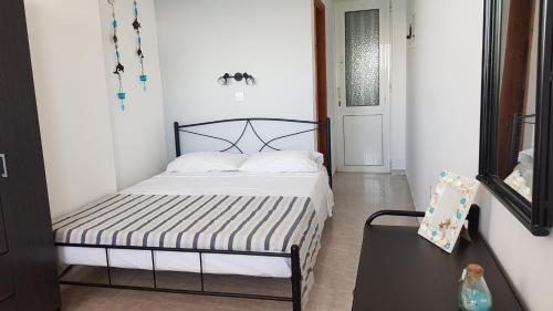 a small bedroom with a bed and a table at Porto Haraki Studios in Haraki