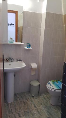 bagno con lavandino, servizi igienici e specchio di Porto Haraki Studios a Haraki