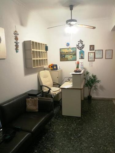 a living room with a black leather couch and a chair at Hotel Rena in Agios Kirykos