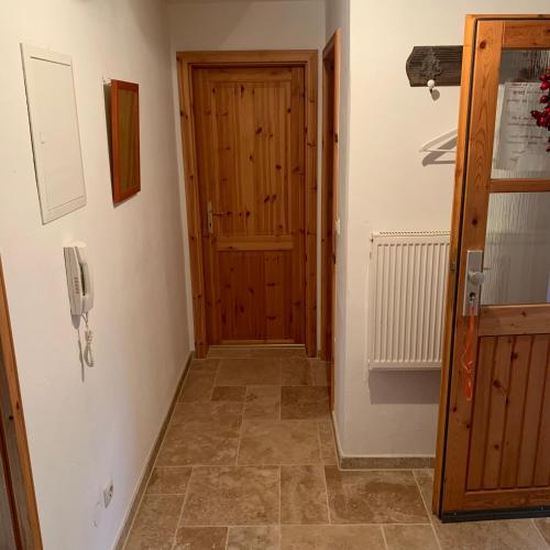 a hallway with a wooden door and a phone on the wall at Apartment with a stunning view of the alps - Wohnung mit atemberaubenden Blick auf die Alpen in Fischbachau