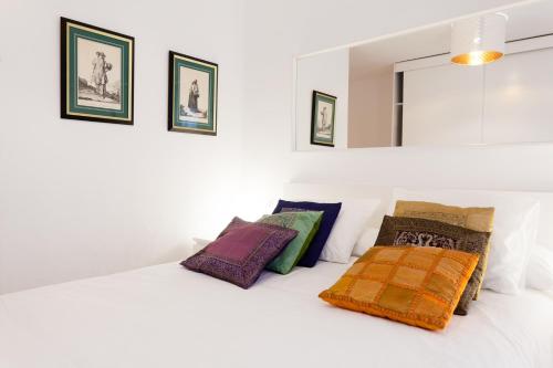 una camera da letto con un letto con cuscini colorati di Patio Budget Apartment 12 a Calonge