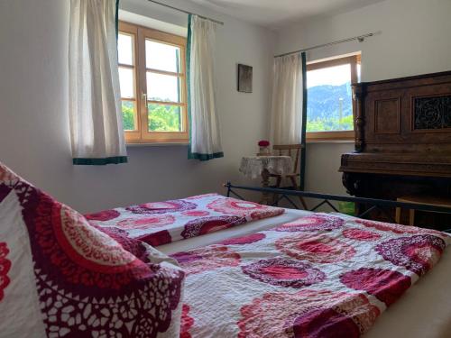 a bedroom with a bed and a piano and windows at Apartment with a stunning view of the alps - Wohnung mit atemberaubenden Blick auf die Alpen in Fischbachau