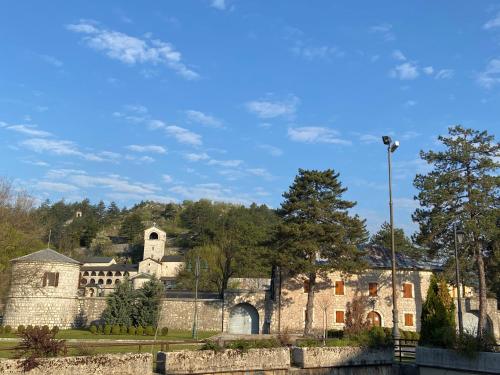 an old stone building with a church in the background at Apartments Kapisoda in Cetinje