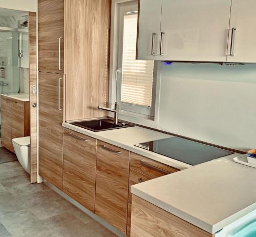 eine Küche mit Holzschränken und einem Waschbecken in der Unterkunft Bonita HouseBoat Apartment Portorose in Portorož
