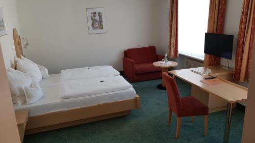 a room with a bed and a desk and a chair at Hotel Gasthof Specht in Aichach