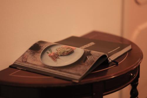 a plate of food on a table with a book at Villa-Hotel De Kroon Gennep in Gennep