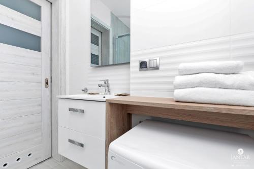 baño con lavabo y encimera con toallas en Jantar Apartamenty - APARTAMENTY KLARA en Grzybowo