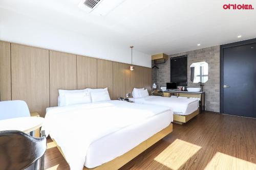a hotel room with two beds and a kitchen at Gwanganri HOTEL OCEANVIEW in Busan