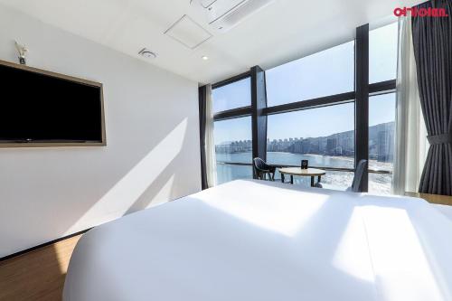 a bedroom with a bed and a large window at Gwanganri HOTEL OCEANVIEW in Busan
