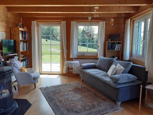 a living room with a couch and two windows at Haus ingrid in Lochau