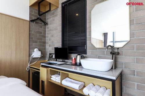 ein Bad mit einem Waschbecken und einem Spiegel in der Unterkunft Gwanganri HOTEL OCEANVIEW in Busan