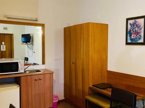 um quarto com uma cozinha com um armário de madeira em County Lodge Motor Inn em West Wyalong