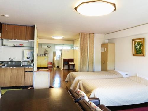 a hotel room with two beds and a kitchen at Fuji Subashiri Condominium Tannpopo in Oyama