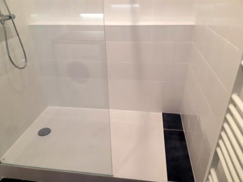 La salle de bains est pourvue d'une douche blanche avec une porte en verre. dans l'établissement Key to Bordeaux - fairytale view, 2 bd + elevator, à Bordeaux
