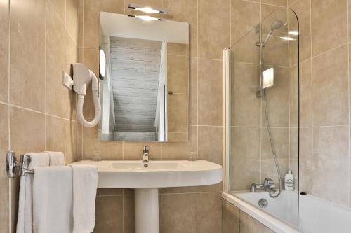 a bathroom with a sink and a shower and a mirror at Hotel Restaurant La Verperie in Sarlat-la-Canéda