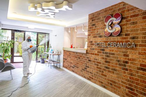 a man is painting a brick wall in a room at Hotel Ceramica in Iaşi