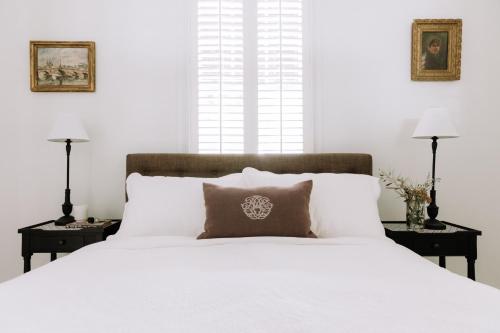 a bedroom with a large white bed with two night stands at French Cottage Beechworth with stunning Alfresco Garden in Beechworth