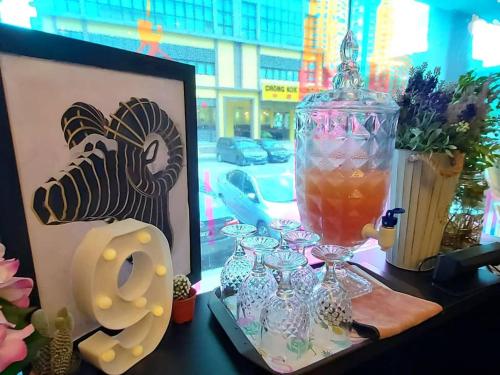 a table with a vase and glasses on it at 9 Square Hotel - Subang in Subang Jaya