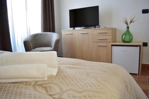 a bedroom with a bed and a tv on a dresser at La Gravina in Gravina in Puglia