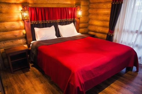 a bedroom with a red bed with a red blanket at Hotel Praha in Uzhhorod