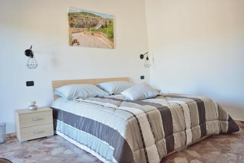 普利亞區格拉維納的住宿－La Gravina，卧室配有一张床,墙上挂着一幅画