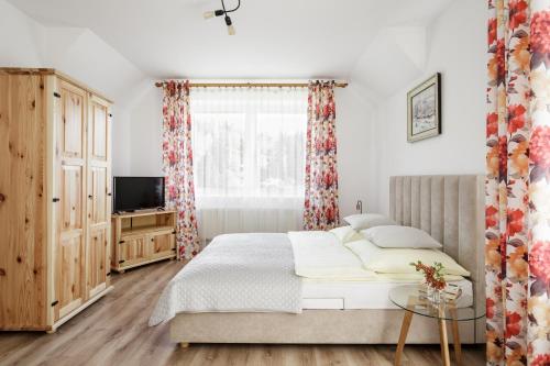 a bedroom with a large bed and a television at Karina in Wisła