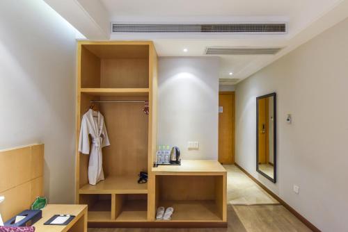 Novo Hotel Chongqing في تشونغتشينغ: غرفة مع خزانة مع حوض فيها