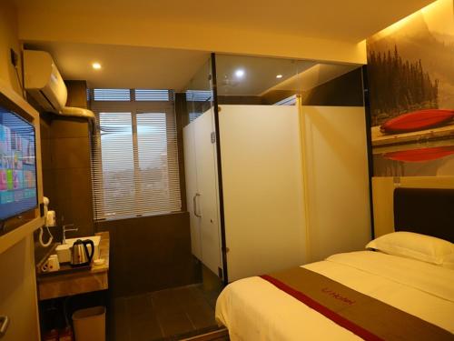 ein kleines Schlafzimmer mit einem Bett und einem TV in der Unterkunft Thank Inn Chain Hotel Jiangxi Ganzhou Longnan County Longxiang Avenue Store in Magutang