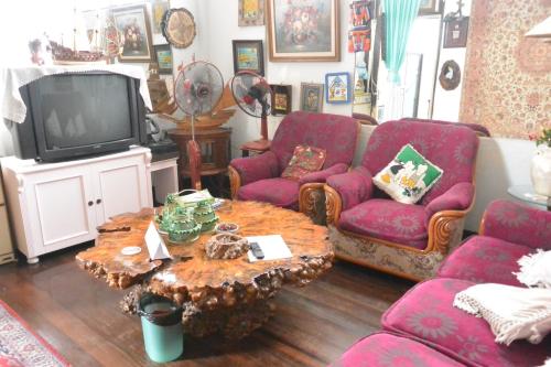 a living room with a table and a tv at King's Home Hua Hin Homestay in Hua Hin