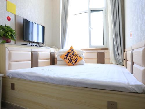 1 dormitorio con 1 cama y TV en JUN Hotels Gansu Lanzhou Lanzhou New District Jing'er Road Asia-Pacific World Trade Center Square en Lanzhou