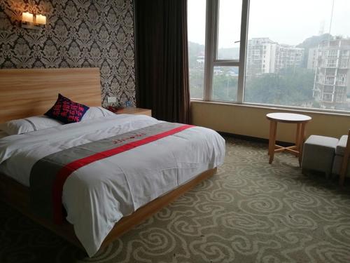 Habitación de hotel con cama y ventana en JUN Hotels Sichuan Chengdu Jianyang Jiancheng Town Jianshe Road, en Jianyang