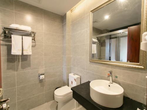 a bathroom with a sink and a toilet and a mirror at JUN Hotels Yingtan Guixi Chengnan Bus Station in Yingtan