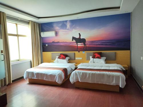 um quarto de hotel com duas camas e uma pintura de um cavalo em JUN Hotels Jiangxi Nanchang Xiyuan em Nanchang