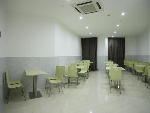 ein Esszimmer mit Tischen und Stühlen in einem Gebäude in der Unterkunft Thank Inn Chain Hotel Jiangxi Ganzhou Longnan County Longxiang Avenue Store in Magutang