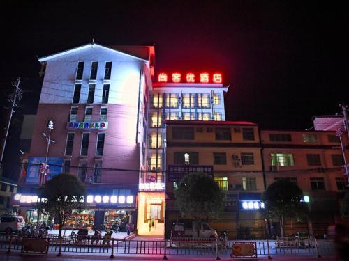 a building with red and white lights on top of it at Thank Inn Chain Hotel Huaihua Tongdao Bus Station in Tongdao